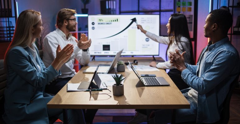 Asian woman showing financial report for colleagues