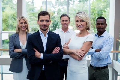 Business executives with arms crossed at conference center