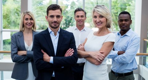 Business executives with arms crossed at conference center