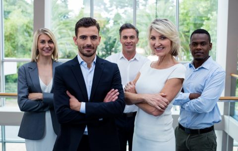 Business executives with arms crossed at conference center