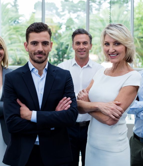 Business executives with arms crossed at conference center