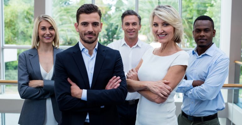 Business executives with arms crossed at conference center