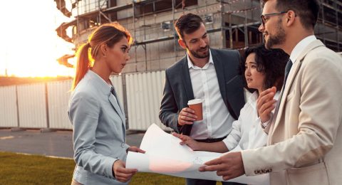 Business people discussing a blueprint in front of the construct