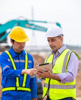 Construction engineer wear safety uniform under inspection and survey workplace by tablet with excav