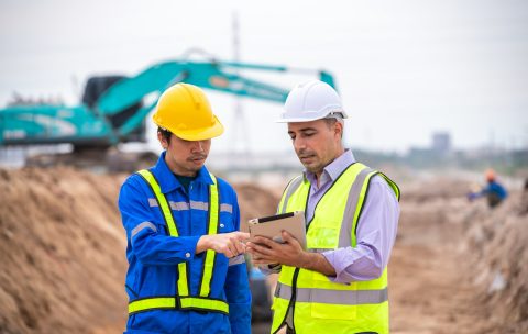 Construction engineer wear safety uniform under inspection and survey workplace by tablet with excav