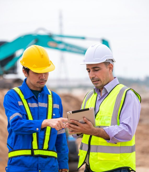 Construction engineer wear safety uniform under inspection and survey workplace by tablet with excav