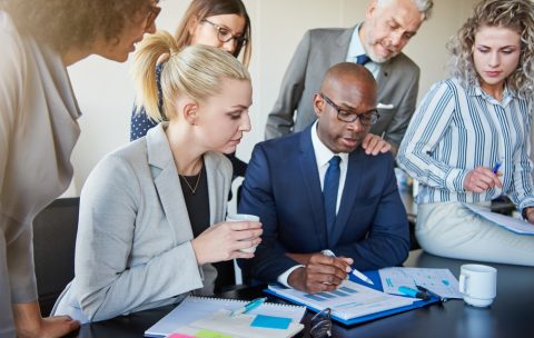Diverse group of executives discussing paperwork around a boardroom table