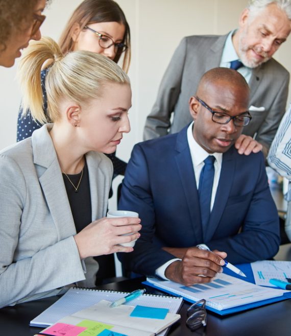 Diverse group of executives discussing paperwork around a boardroom table