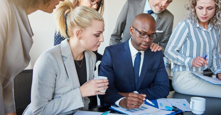 Diverse group of executives discussing paperwork around a boardroom table