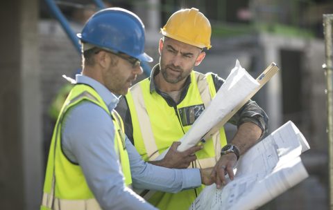 Project manager and construction worker looking at plans
