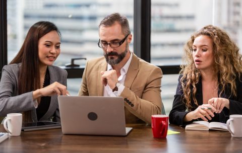 Group of businesspeople watching financial report on computer la